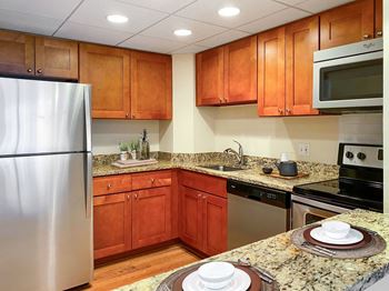 A kitchen with wooden cabinets and granite countertops. at Lenox Club, Arlington, VA, 22202